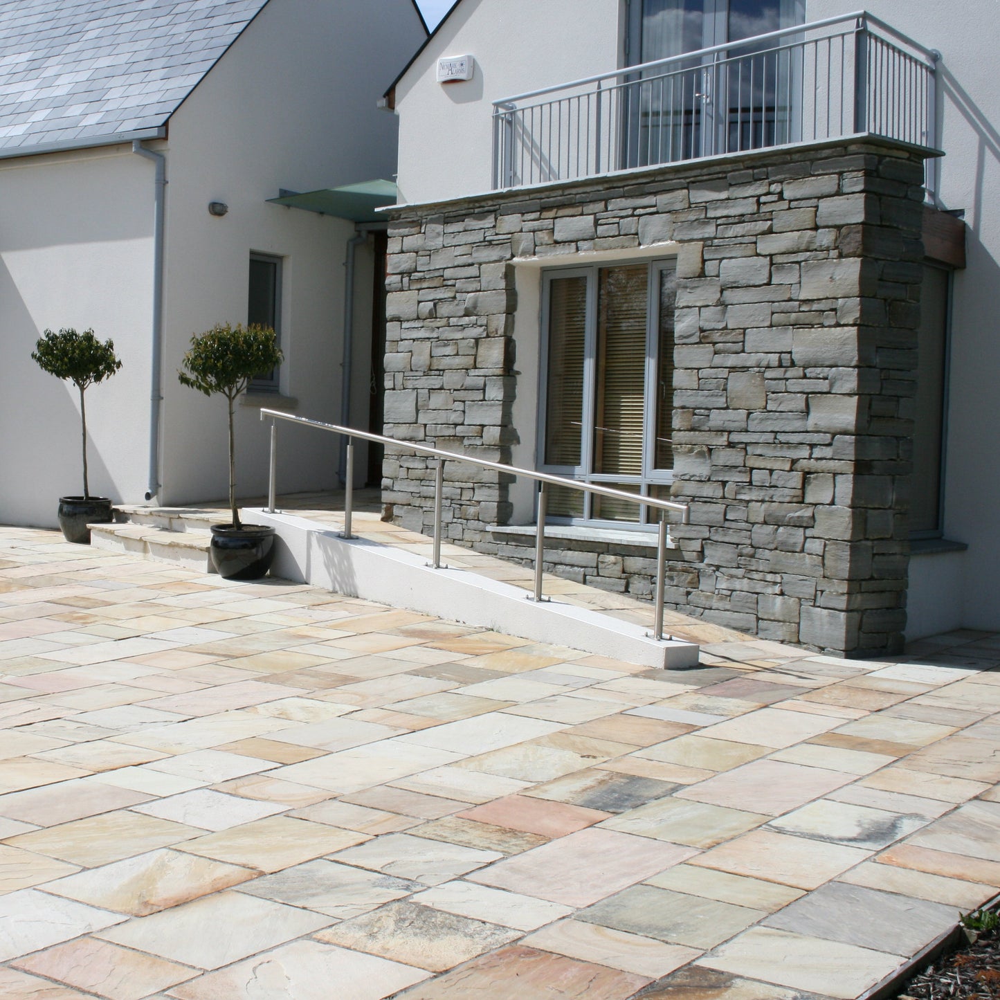 Modern house with patio area to the front featuring Tinted Mint Sandstone paving. 