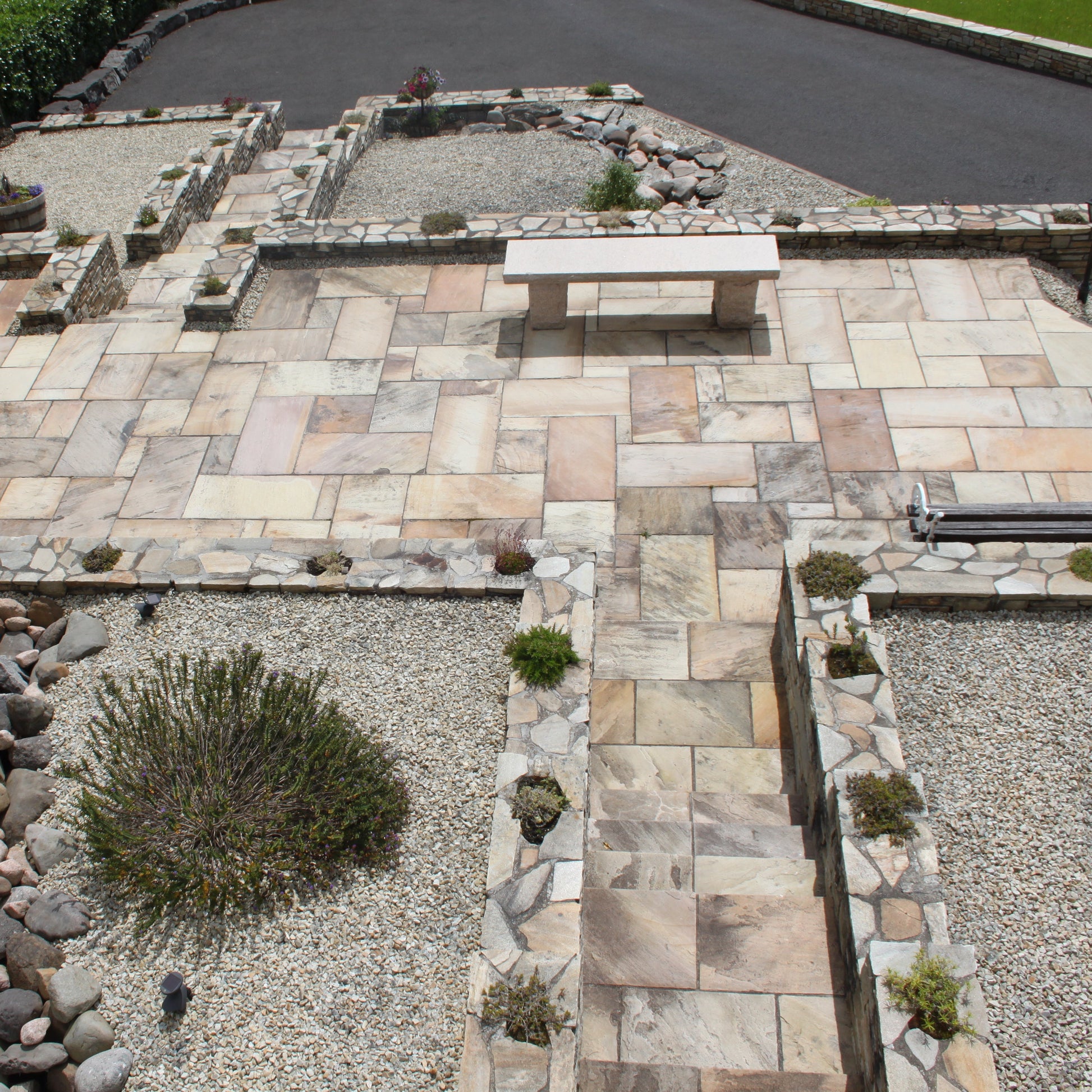 Overhead view of raised patio area with steps featuring Tinted Mint Sandstone paving. 
