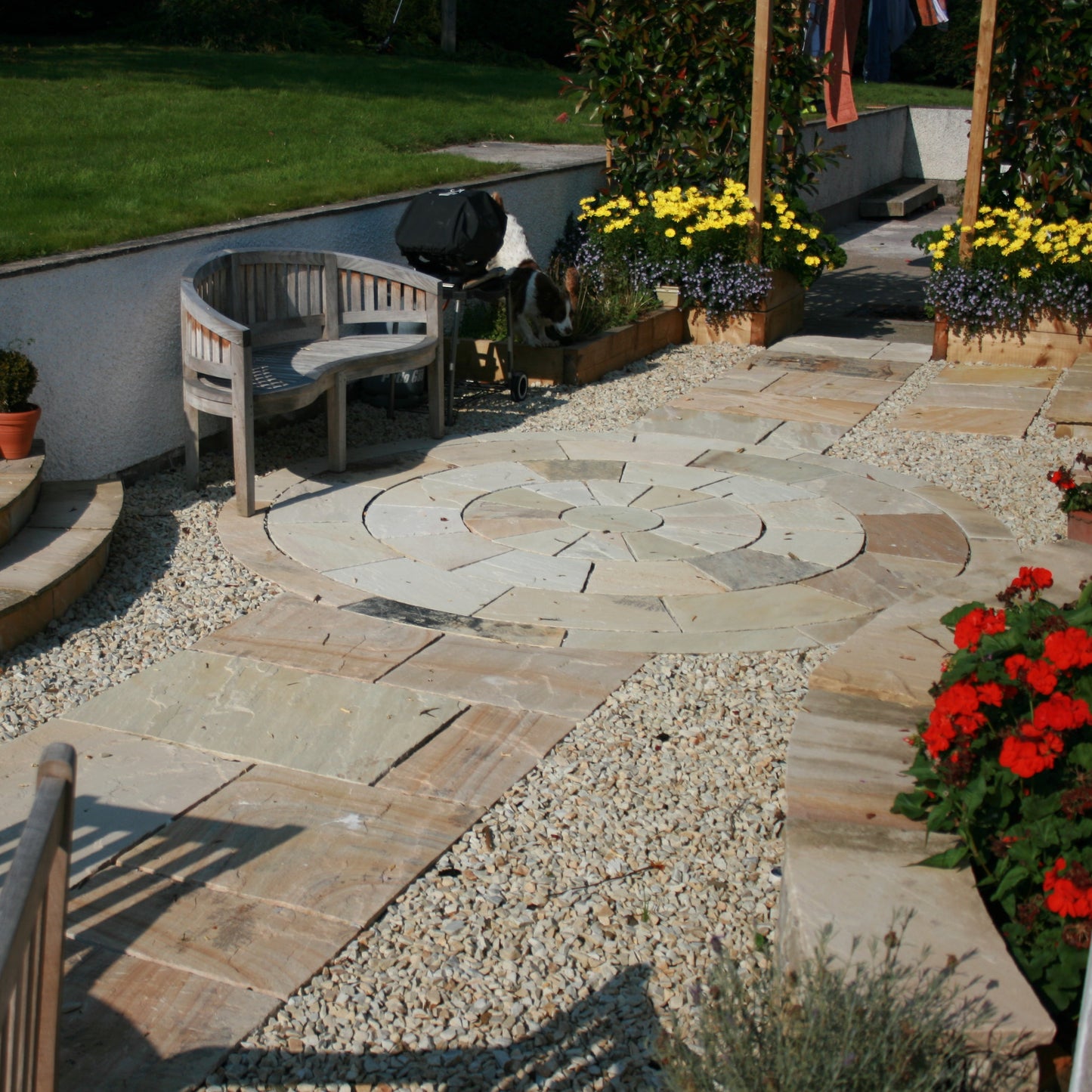 Pathway featuring Tinted Mint Sandstone Paving and Circle, surrounded by natural stone chipping and planting. 