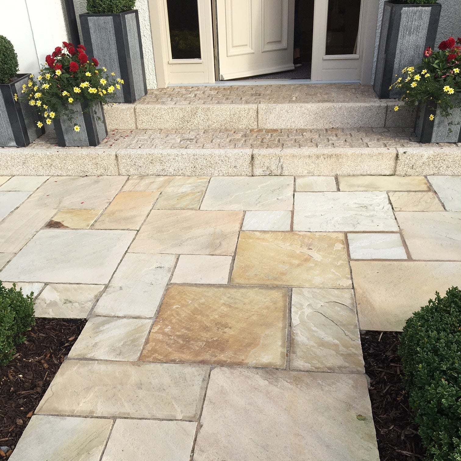 Pathway in Tinted Mint Sandstone Paving leading towards a house entrance. 