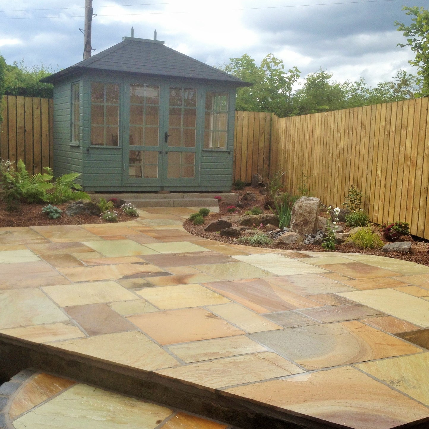 Patio area with outdoor room featuring Tinted Mint Sandstone Paving in patio pack sizes. 