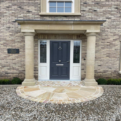 A 2.5m diameter Tinted Mint Sandstone circle installed with Tinted Mint Sandstone Cobbles at the doorway of a brick house creating an elegant entrance.