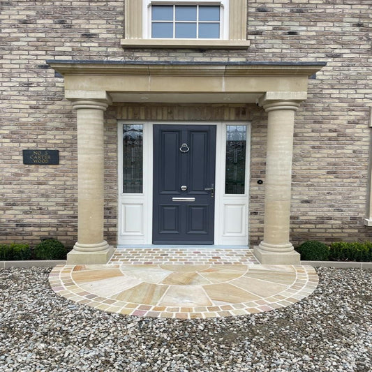 A 2.5m diameter Tinted Mint Sandstone circle installed with Tinted Mint Sandstone Cobbles at the doorway of a brick house creating an elegant entrance.