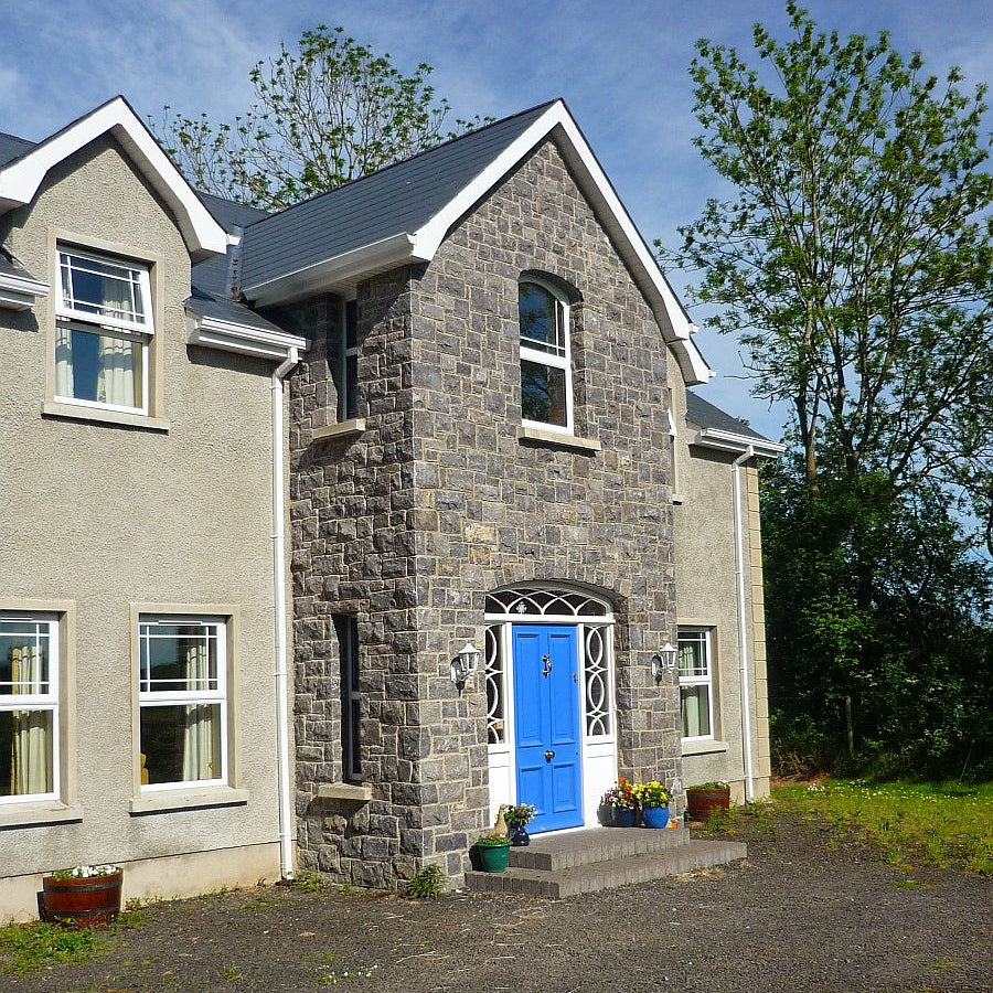 Two storey house with stone façade in white limestone machine block. 