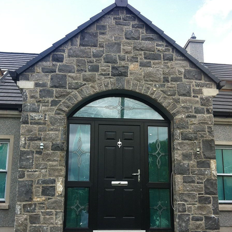 Stone porch with black door. Stone is white limestone machined walling stone. 