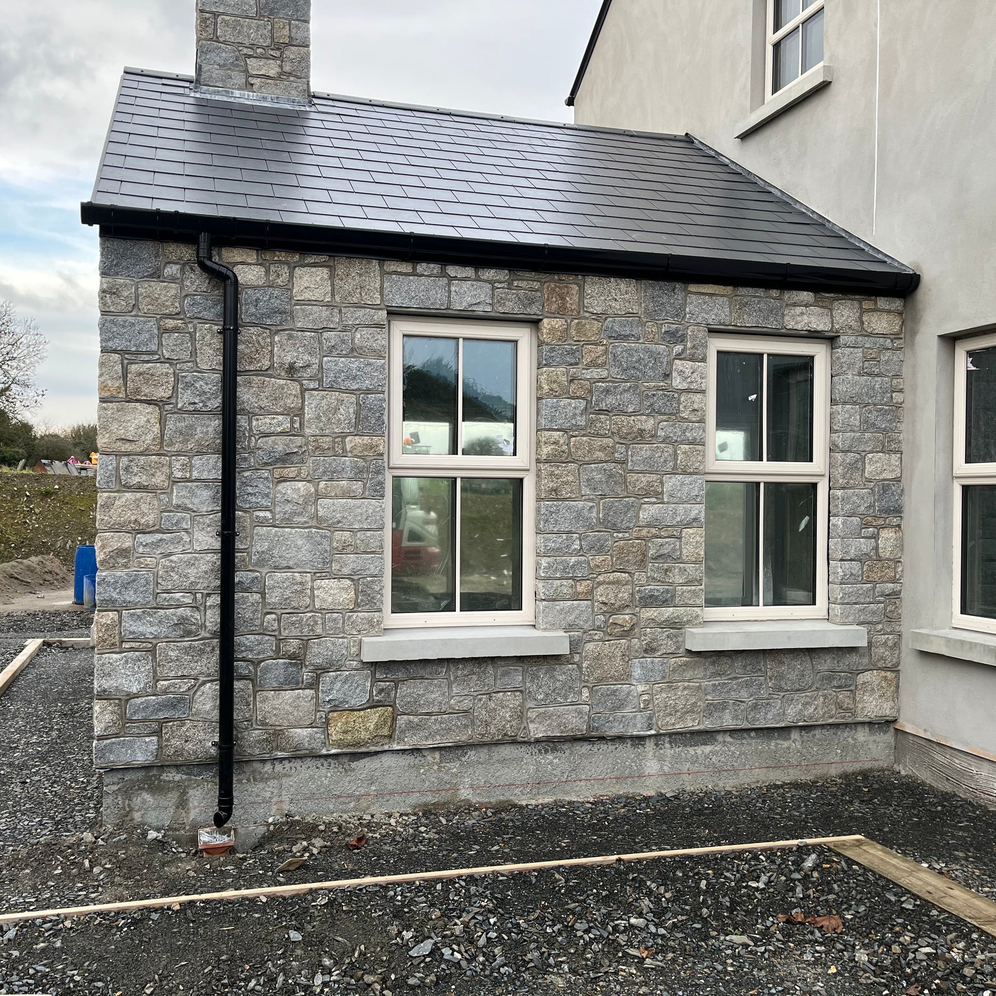 Newly built house with stone facade in Wicklow Granite building stone and black roof