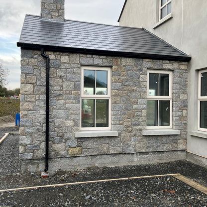 Newly built house with stone facade in Wicklow Granite building stone and black roof