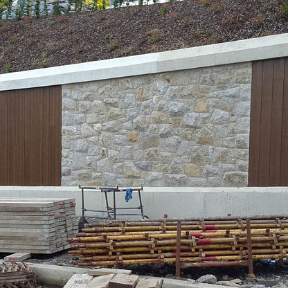 Landscaping feature wall showcasing Wicklow granite machined building stone and wooden cladding. Construction materials in the foreground. 