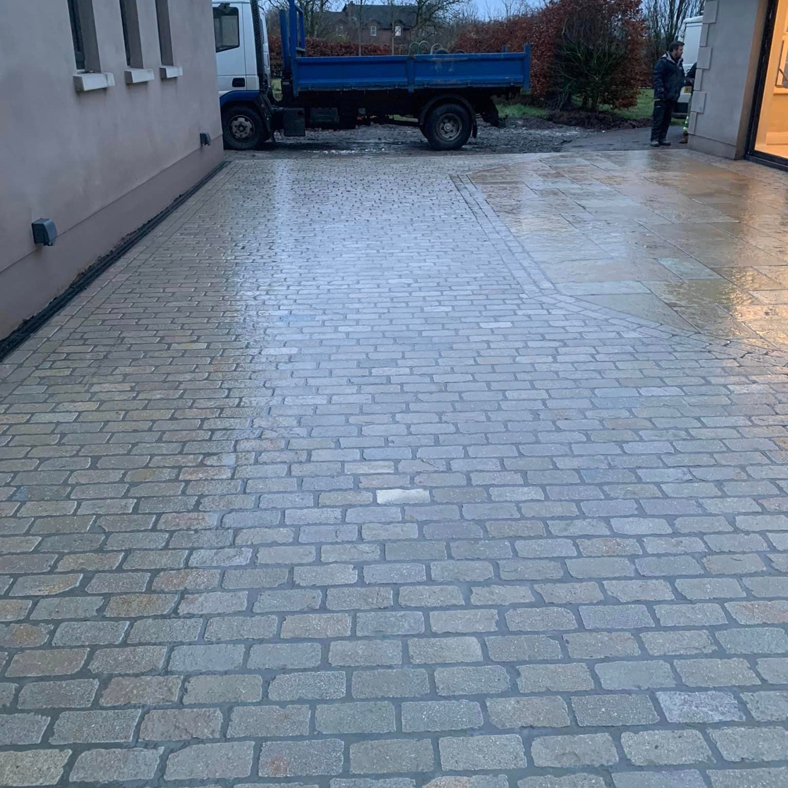 A set of yellow limestone setts laid on the ground, with a truck parked near them. 