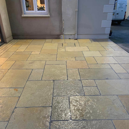 Patio area completed using Yellow Limestone Tumbled Paving. Photographed wet in late evening. 