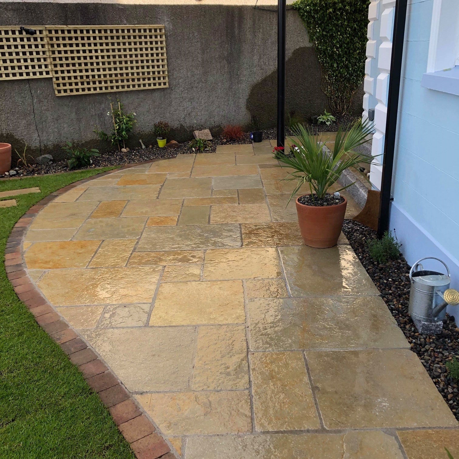 Curved patio featuring Yellow Limestone Tumbled Paving in patio pack sizes. 