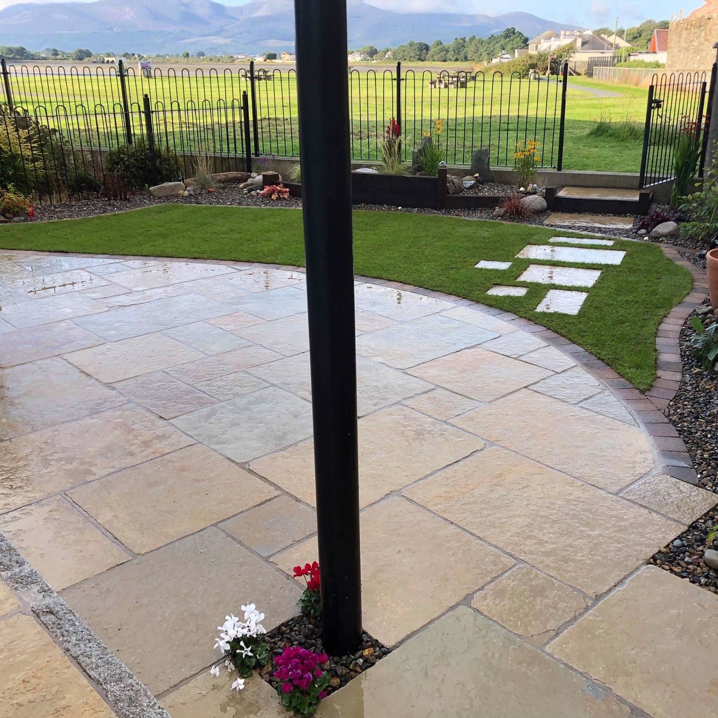 Wet patio area showcasing Yellow Limestone Paving in Tumbled Patio Pack format. 